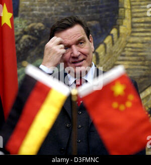 (Afp) - Le Chancelier allemand Gerhard Schroeder touche la tête lors de la signature de plusieurs contrats bilatéraux à Beijing, Chine, le lundi 6 décembre 2004. Visites Schroeder conjointement avec le ministre de l'Intérieur allemand Otto Schily et ministre allemand des Transports Manfred Stolpe Chine pendant deux jours et se réunira pendant ce temps avec le Premier ministre chinois Wen Jiabao et le président chinois Hu Jintao. Banque D'Images