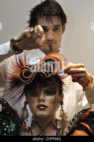 (Dpa) - Christoph Schildmann, coiffeur champion du monde juniors pour les cheveux des femmes, présente sur un modèle d'aperçu de la dernière coupe de cheveux à l'occasion de la foire de Stuttgart, Allemagne, 22 novembre 2004. Près de 100 exposants seront montrant la coiffure de l'automne/hiver 2004/05, facettes et tendance à la stylings salon 'hair and style' à Stuttgart entre 28 et 29 No Banque D'Images