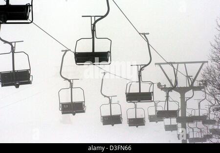 (Afp) - Les sièges vides d'un télésiège sont vus contre un ciel gris sur la montagne Feldberg en Forêt-Noire, Allemagne, 22 novembre 2004. La saison de ski sur le Feldberg est ouverte le 21 novembre 2004. Banque D'Images