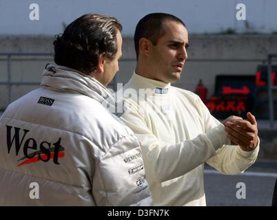 (Afp) - pilote de Formule 1 colombien Juan Pablo Montoya (R) des gestes aussi il parle avec les membres de l'équipe McLaren-Mercedes sur le circuit de Catalogne à Barcelone, Espagne, 25 novembre 2004. Montoya, qui est toujours sous contrat avec l'équipe Williams-BMW, a reçu la permission de tester pour sa nouvelle équipe McLaren-Mercedes pour qui il pilotera dans la prochaine saison de F1 2005. Banque D'Images