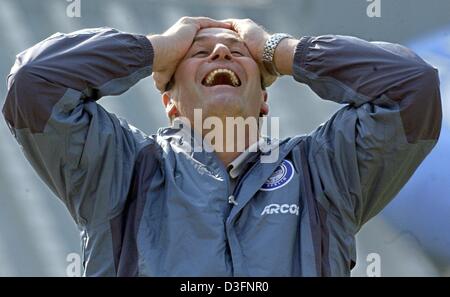 (Afp) - l'entraîneur de football Huub Stevens des Pays-Bas touche la tête et rire gêné comme l'un de ses joueurs est envoyé et son équipe doit continuer le match avec dix joueurs de Bundesliga à Berlin's Olympia Stadium, le 12 avril 2003. Herta BSC Berlin gagne 1-0 contre le VfL Bochum. Banque D'Images