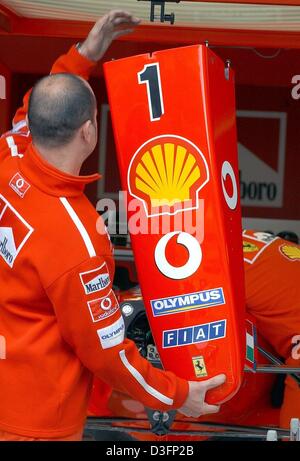 (Afp) - Un mécanicien de soldes Ferrari le capot d'une voiture de course de Formule Un dans ses mains dans la fosse à Ferrari A1-Ring racetrack près de Zeltweg, Autriche, 15 mai 2003. Les équipes de course pour préparer le grand prix d'Autriche qui est la sixième course menant à la formule un worldchampionship et qui va commencer le 18 mai 2003. Banque D'Images