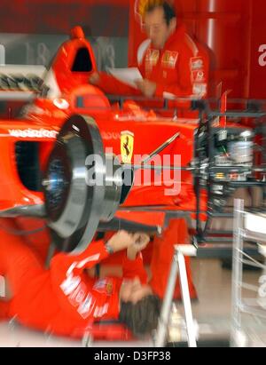 (Afp) - Un mécanicien couches au fond d'une voiture de course de formule un Ferrari dans le noyau à l'A1-Ring racetrack près de Zeltweg, Autriche, 15 mai 2003. Les équipes de course pour préparer le grand prix d'Autriche qui est la sixième course menant à la formule un worldchampionship et qui va commencer le 18 mai 2003. Banque D'Images