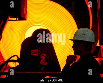 (Afp) - Un employé d'EKO Stahl GmbH est le contrôle du laminage à chaud en Eisenhuettenstadt, Allemagne, 24 avril 2003. EKO Steelworks appartient au groupe Arcelor et fournit de l'acier plat à l'Est, en particulier à l'usines en Pologne, République tchèque et BMW à Leipzig, en Allemagne. EKO emploie environ 3 000 personnes et a augmenté sa production d'acier brut de 2,5 millions de tonnes en 2002. L Banque D'Images