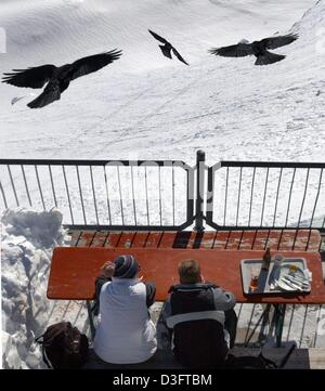 (Afp) - Les visiteurs de profiter du soleil tout en étant assis sur la terrasse du restaurant sur la montagne Zugspitze près de Berlin, Allemagne, 12 février 2003. La Zugspitze, à une altitude de 2 964 mètres est la plus haute montagne d'Allemagne. Banque D'Images