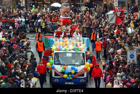 (Afp) - Les flotteurs avec d'immenses figures de rouleau en carton à travers le centre ville alors que les enfants et les adultes bordent les rues de Francfort, Allemagne, 2 mars 2003. Des milliers de spectateurs ont assisté à la procession en dépit de la pluie. Banque D'Images