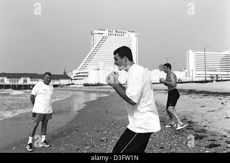 (Afp) - Les boxeurs poids lourd ukrainien Wladimir Klitschko (avant) et son frère Vitali jette quelques coups en l'air sur la plage d'Atlantic City, New Jersey, USA, 28 juin 2002. Sur la gauche de leur entraîneur allemand Fritz Sdunek. Banque D'Images