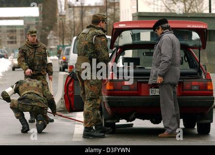 (Afp) - Des soldats allemands mener les contrôles de sécurité avec des miroirs sous une voiture à la porte de la caserne de George C. Marshall à Garmisch-Partenkirchen, Allemagne, 29 janvier 2003. Les soldats allemands sont gardant les installations de l'armée américaine en Allemagne. Banque D'Images