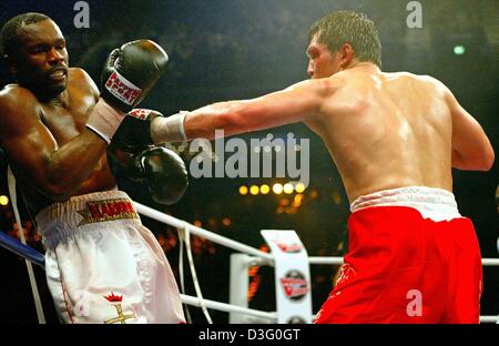 (Afp) - Le boxeur polonais Dariusz Michalczewski (R), l'actuel champion du monde de boxe poids lourd léger étend son bras pour un poinçon contre le challenger pour le titre, le boxeur américain Derrick Harmon durant la WBO (World Boxing Organisation) champions du monde lutte à Hambourg, Allemagne, 29 mars 2003. Michalczewski remporte le combat avec un coup dans le 9ème tour. C'était la 23e ti Banque D'Images