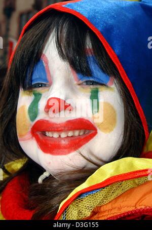 (Afp) - La jeune fille Anna Maria (5) heureusement présente son visage peint de couleurs vives pendant la procession carnaval à Francfort, Allemagne, 2 mars 2003. Des milliers de spectateurs ont assisté au défilé en dépit d'un temps pluvieux. Banque D'Images