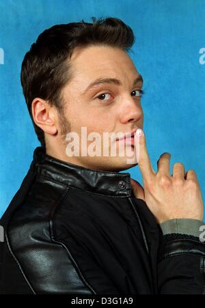 (Afp) - le chanteur pop italien Tiziano Ferro holding gestes un doigt à ses lèvres à Cologne, Allemagne, 28 mars 2003. Banque D'Images