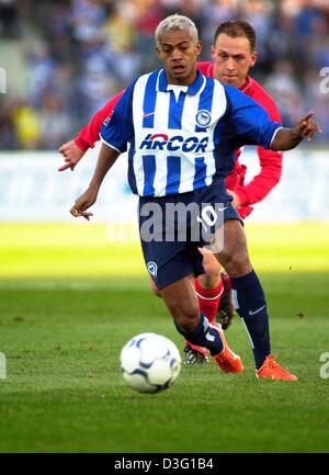 (Afp) - l'attaquant brésilien Marcelinho (avant), avec orange formateurs, est poursuivi par le milieu de Cottbus' Timo Rost pendant la partie de football Bundesliga Hertha BSC Berlin contre le FC Energie Cottbus à l'Olympia Stadium de Berlin, 23 mars 2003. Berlin a gagné 3-1 et se classe actuellement au quatrième rang alors que Cottbus se classe à la dernière place dans la première ligue allemande. Banque D'Images