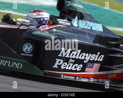 (Afp) - un conducteur formual néerlandais Jos Verstappen (Minardi) dispose d'un grand autocollant placé sur sa voiture de course de Formule 1 au cours de laquelle il conduit la course de grand prix de Formule 1 à Sepang, près de Kuala Lumpur, Malaisie, 23 mars 2003. L'étiquette de "Malaisie pour la paix". Jos Verstappen vient dans le 13e place à la course de grand prix de formule 1 de Malaisie. Banque D'Images