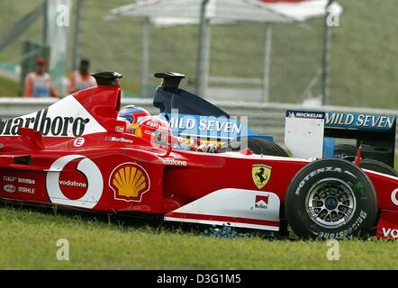 (Afp) - formule 1 l'Allemand Michael Schumacher (Ferrari) (avant) s'arrête sur l'espace vert à côté du pilote italien Jarno Trulli (Renault) (retour) après avoir conduit contre Trulli au troisième tour sur le circuit de Formule 1 durant le grand prix de Formule 1 race à Sepang, près de Kuala Lumpur, Malaisie, 23 mars 2003. Schumacher a été sanctionné pour ce preventible wi collision Banque D'Images