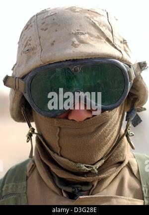 (Afp) - US marine Lance Corporal Ron McClary de la 8e Force de garde se protège de la poussière et du sable avec une paire de lunettes et un morceau de tissu au Camp Coyote, le Koweït, le 13 mars 2003. Plus de 150 000 soldats américains et britanniques sont actuellement basés au Koweït pour le nord désertique. Selon le département américain de la Défense, ces soldats sont prêts à lancer une attaque contre l'Irak. Banque D'Images