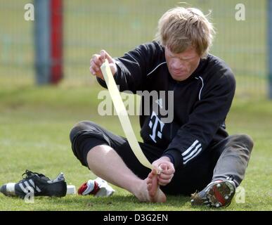 (Afp) - le gardien du Bayern Munich Oliver Kahn bandages son pied droit lors d'une session de formation sur le terrain dans la région de Munich, Allemagne, 11 mars 2003. FC Bayern Munich mène avec 13 points dans le championnat de Bundesliga et est en passe de remporter le 18e titre de champion d'Allemagne. Banque D'Images