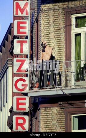 (Afp) - un mannequin se dresse sur un balcon avec un masque à gaz tiré sur la face à Francfort, Allemagne, 19 février 2003. Le panneau sur le côté du bâtiment lire 'boucher'. Banque D'Images