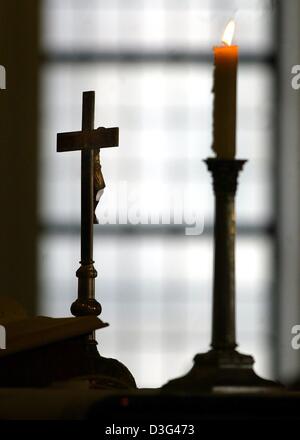 (Afp) - un crucifix est à côté d'une bougie allumée sur l'autel au cours d'un service de l'principaux dirigeants des Églises Protestantes en Europe, dans la cathédrale française de Berlin, 5 février 2003. Les membres de l'église d'Europe, des Etats-Unis et du Moyen-Orient se sont réunis afin de concert à trouver la réponse à la menace de guerre en Irak. Banque D'Images