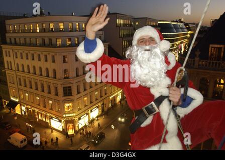 (Afp) - un Père Noël de belles descentes en bas de la façade d'un bâtiment dans la rue Friedrichstrasse (Friedrich) à Berlin, le 16 décembre 2003. L'événement était organisé par l'UNICEF afin de recueillir des fonds pour l'UNICEF sur l'une des rues principales de Berlin. Banque D'Images