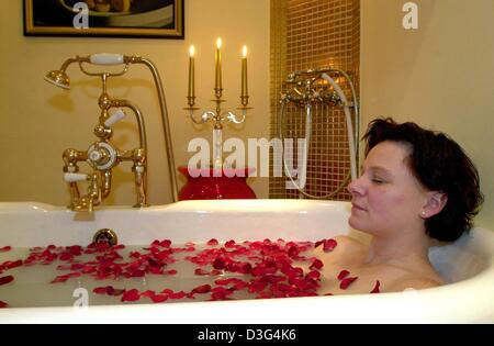 (Afp) - une jeune femme se détend dans une substance laiteuse recouverte de pédales rose dans un bain à remous de l''hôtel Maritim Kaiserhof dans la station balnéaire de Heringsdorf, Allemagne du nord, le 19 novembre 2003. La soi-disant "Kaiserbad" (baignoire de l'empereur) est composé d'eau de mer, le lait de chèvre, de miel et d'huiles différentes. Banque D'Images