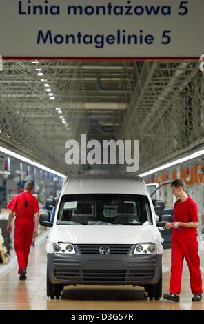 (Afp) - Un employé (R) travaille sur l'un de la nouvelle VW Caddy cars alors qu'un autre travailleur promenades le long de la chaîne de montage de l'usine d'assemblage de Volkswagen, Pologne, 26 novembre 2003. Avec le début de la production de la fourgonnette, Volkswagen a célébré en même temps que le dixième anniversaire de son lieu de production en Pologne. L'entreprise emploie plus de 5 000 employés dans quatre prod Banque D'Images