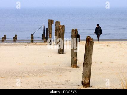 (Afp) - poteaux en bois pourri marquer la limite actuelle de la frontière extérieure de l'UE entre l'Allemagne et la Pologne sur la plage de Nice, sur l'île Usedom, Allemagne, 14 novembre 2003. Une poussette fait une promenade du côté polonais de la frontière. Après la frontière polonaise la police a démantelé la clôture métallique il y a plusieurs semaines, l'Allemand patrouille de la police des frontières la frontière 'Ouvrir' et éviter Banque D'Images