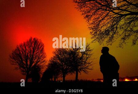 (Afp) - Juste avant minuit un observateur regarde un impressionnant spectacle de lumières du nord près de Doebberin, Allemagne du nord, 20 novembre 2003. Le phénomène n'est pas visible chaque année. Northern Lights proviennent de notre soleil. Au cours de grandes explosions et de fusées, d'énormes quantités de particules solaires sont mis dehors du soleil et dans l'espace lointain. Lorsqu'ils se rapprochent de la terre, ils Banque D'Images