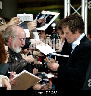 (Afp) - L'acteur britannique Hugh Grant, signe des autographes avant la première Allemande de son film 'Love Actually' à Munich, 14 novembre 2003. Banque D'Images