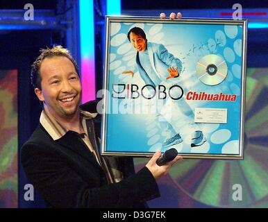 (Afp) - La pop star Suisse DJ Bobo présente son album d'or qu'il a reçu pour son hit 'Chihuahua' au cours de l'émission de télévision ARD 'Gold, Gold, Gold' à Hambourg, Allemagne, 7 novembre 2003. Banque D'Images