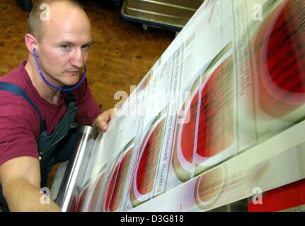 (Afp) - Un employé de British American Tobacco travaille sur une ligne d'emballage de paquets de cigarettes Lucky Strike pour le marché espagnol, à Bayreuth, Allemagne, 24 octobre 2003. 1 200 employés produisent 32 millions de cigarettes chaque année. Les principales marques sont Lucky Strike, Pall Mall et HB. Banque D'Images