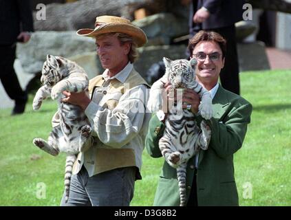 (Dpa) - Roy Horn (R) et Siegfried Fischbacher (L) de l'animal magicien Siegfried et Roy "duo", jouer avec un tigre blanc au Hollywood Parc Safari à Stuckenbrock, Allemagne, 16 janvier 1997. Roy Horn est en convalescence après avoir été attaqué par un tigre sur scène à Las Vegas le 3 octobre 2003. Les 59 ans, l'interprète d'origine allemande, a été mordu par un tigre du Bengale dans le cou un Banque D'Images