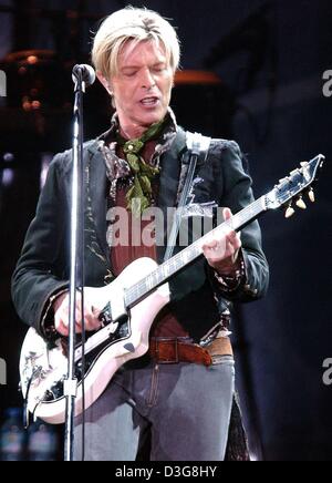 (Afp) - David Bowie est sur scène devant un micro et joue de la guitare pendant son concert à la Color Line Arena de Hambourg, Allemagne, 16 octobre 2003. Le chanteur britannique a commencé l'étape de sa tournée mondiale au cours de laquelle il présentera son nouvel album 'réalité'. Banque D'Images