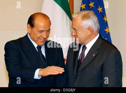 (Afp) - Le Premier ministre et actuel président du Conseil Silvio Berlusconi (L) des gestes avec sa main comme un accueille le Premier ministre polonais Leszek Miller lors du sommet européen de Bruxelles, Belgique, 16 octobre 2003. La Pologne va rejoindre l'Union européenne dans le cadre de l'expansion vers l'Europe de l'Est en mai 2004 en tant que nouveau membre. Banque D'Images