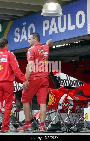 (Afp) - la mécanique de Formule Un Ferrari promenade à travers les stands à la piste de course d'Interlagos à Sao Paulo, le mercredi 20 octobre 2004. La finale du Championnat du Monde de Formule 1 2004 se tiendra à Sao Paulo le dimanche. Banque D'Images