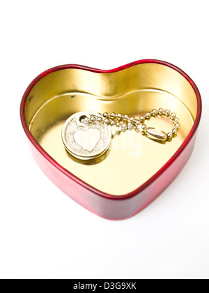 Un cœur en acier inoxydable doré avec un coeur miniature key-chain isolé sur fond blanc Banque D'Images