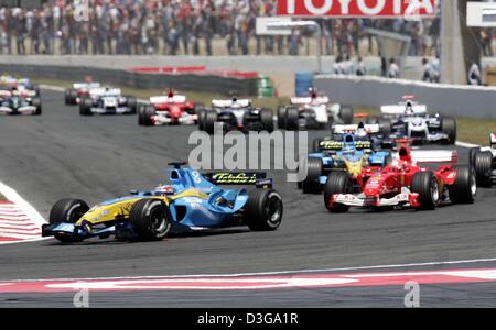 (Afp) - pilote de Formule 1 espagnol Fernando Alonso (L, à l'avant) de Renault mène le domaine des voitures de course après le début de la Grand Prix de France à Magny-Cours, France, 4 juillet 2004. Banque D'Images