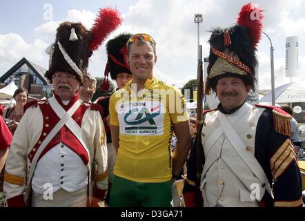 (Afp) - le cycliste norvégien Thor Hushovd (C) de l'équipe Crédit Agricole, qui porte le maillot jaune de leader au classement général, le sourire tout en se tenant dans entre deux hommes habillés en uniforme militaire traditionnel de l'époque de la grande bataille de Waterloo en 1819 avant le début de la troisième étape du Tour de France à Waterloo, Belgique, le 6 juillet 2004. La troisième étape longue de 210km et de Banque D'Images