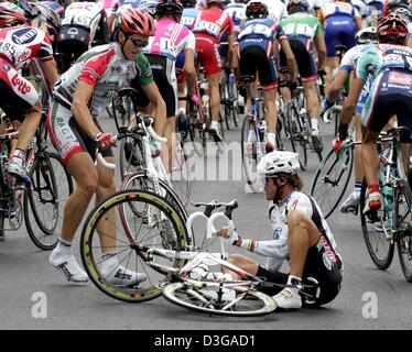 (Afp) - le cycliste italien Mario Cipollini (R) de l'équipe Domina Vacanze tente de se relever après avoir perdu avec le français Guillaume Auger (L) au cours de la première étape du Tour de France, près de Liège, Belgique, 4 juillet 2004 près de Liège. La première et longue étape en investissant 202,5 millions km du 91e Tour de France cycliste a pris les cyclistes de Liège à Charleroi. Banque D'Images