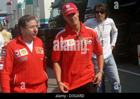 (Afp) - Le chef de l'équipe Ferrari, Jean Todt, parle à l'Allemand pilote de Formule 1 Michael Schumacher (Ferrari) de l'Équipe sur la piste de course à Imola, Italie, 25 avril 2004. Banque D'Images