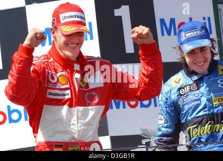 (Afp) - un pilote et le pilote allemand Michael Schumacher (Ferrari gagnant, L) et deuxième placé Fernando Alonso (Renault) jubilate sur le podium après avoir remporté le Grand Prix de France à Magny Cours la course parcours en France, le 4 juillet 2004. Six fois champion du monde, Schumacher remporte sa neuvième course de la saison, correspondant à son propre record de sept victoires à une race. Il est maintenant également propriétaire Banque D'Images