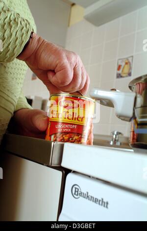 (Afp) - une femme plus âgée s'ouvre une boîte de soupe de lentilles à Francfort, Allemagne, 19 octobre 2004. Banque D'Images