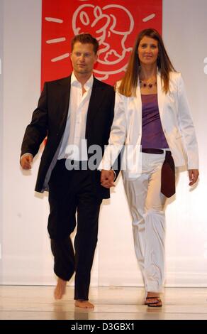 (Afp) - L'acteur allemand Til Schweiger et sa femme Dana marche main dans la main sur la passerelle pendant la 4e gala de bienfaisance de la mode "Événement important" à Hambourg, Allemagne, 31 octobre 2004. Plus de quarante personnes célèbres du cinéma, de la télévision, des médias, du sport et du spectacle présenté par les concepteurs de mode réussie pour une bonne cause. Le produit de la soirée sera reversé à l'Hambourg 'Leuchtfeuer' h Banque D'Images