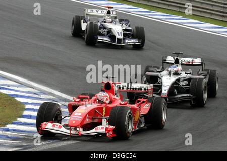 (Afp) - pilote de Formule 1 brésilien Rubens Barrichello (avant) de Ferrari est suivie par le pilote de Formule 1 Kimi Raeikkoenen (McLaren Mercedes) et colombien Juan Pablo Montoya (BMW-Williams) au cours de la Formule Un Grand Prix du Brésil à Interlagos le circuit dans Sao Paulo, Brésil, 24 octobre 2004. Banque D'Images