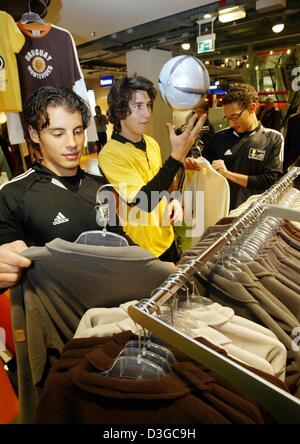 (Afp) - Trois jeunes amateurs de soccer inspecter les marchandises à la vente à un officiel de la Coupe du Monde FIFA 2006 shop situé dans un grand magasin à Francfort, Allemagne, 14 octobre 2004. Jusqu'au 15 novembre 2004 Coupe du monde boutiques est ouvert dans les 12 villes hôtes vente de chapeaux, t-shirts, des ballons de foot et beaucoup d'autres marchandises du ventilateur. Banque D'Images