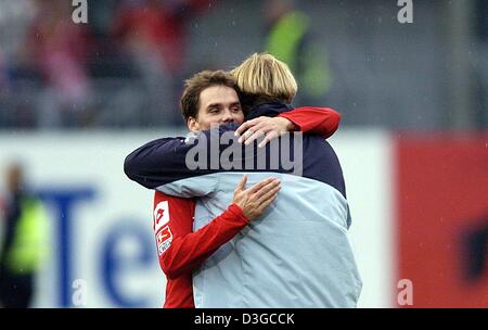 (Afp) - L'entraîneur-chef Juergen Klopp (avant) hugs terrain Niclas Weiland, qui a marqué l'égalisation 1-1, après la fin de la Bundesliga match entre FSV Mainz 05 et le Werder Brême à Bruchweg Stadium à Mainz, Allemagne, 16 octobre 2004. Promu Mayence a battu le champion en titre allemand Bremen par un score de 2-1. Banque D'Images