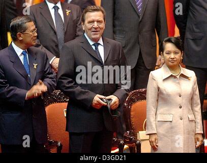 (Afp) - Le Chancelier allemand Gerhard Schroeder est flanqué par le Premier ministre cambodgien Hun Sen (L) et la présidente philippine Gloria Macapagal-Arroyo (R) lors de la cérémonie d'ouverture de la 5e réunion Asie-Europe (ASEM 5) à Hanoi, Vietnam, 8 octobre 2004. Le sommet de deux jours est destiné à renforcer la coopération et le dialogue entre l'Europe et l'Asie, mais a été éclipsé par la ligne ove Banque D'Images