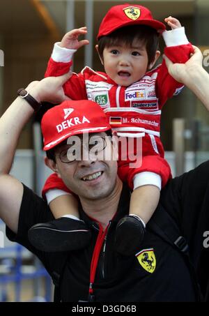 (Afp) - un jeune fan Ferrari assis sur les épaules de son père attend pour une comparution de l'Allemand pilote de Formule 1 et champion du monde en titre Michael Schumacher et son coéquipier brésilien Rubens Barrichello Ferrari à un événement de parrainage à Tokyo, Japon, le 6 octobre 2004. Le Grand Prix du Japon aura lieu à Suzuka International Racing course le dimanche 10 octobre 2004. Banque D'Images