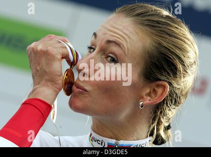 (Afp) - Le cycliste Suisse Karin Thuerig embrasse sa médaille d'or après avoir remporté l'épreuve individuelle féminine course du championnat du monde de cyclisme à Bardolino, Italie, 28 septembre 2004. Thuerig a remporté l'épreuve devant l'Allemagne et de Judith Arndt Zoulfia Zabirova russe. Banque D'Images