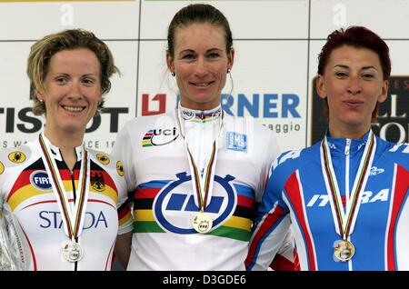 (Afp) - Le cycliste Suisse Karin Thuerig (C) est flanquée d'Allemagne Judith Arndt (L) et le russe Zoulfia Zabirova sur le podium après l'épreuve individuelle féminine de la course championnat du monde de cyclisme à Bardolino, Italie, 28 septembre 2004. Thuerig a remporté l'épreuve devant Arndt et Zabirova. Banque D'Images