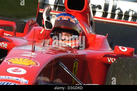 (Afp) - pilote de Formule 1 brésilien Rubens Barrichello (Ferrari) cheers après avoir remporté le Grand Prix de Chine sur le nouveau Circuit International de Shanghai à Shanghai, Chine, le 26 septembre 2004. Banque D'Images